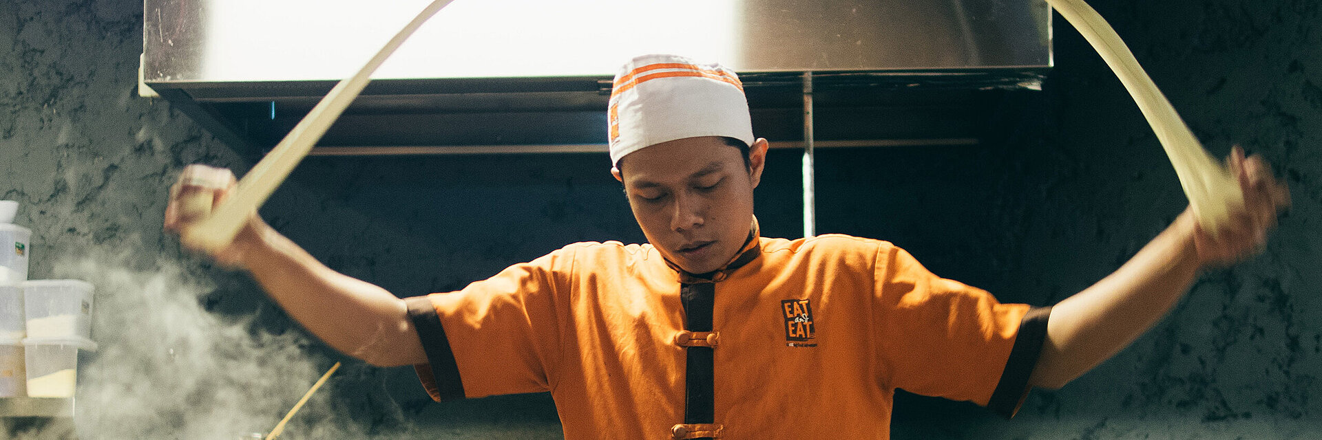 [Translate to Hongkong (Englisch):] Asian cook with embroidered working shirt