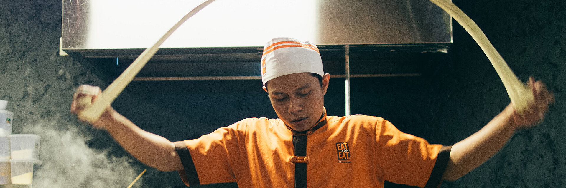 [Translate to Global Spanisch:] Asian cook with embroidered working shirt