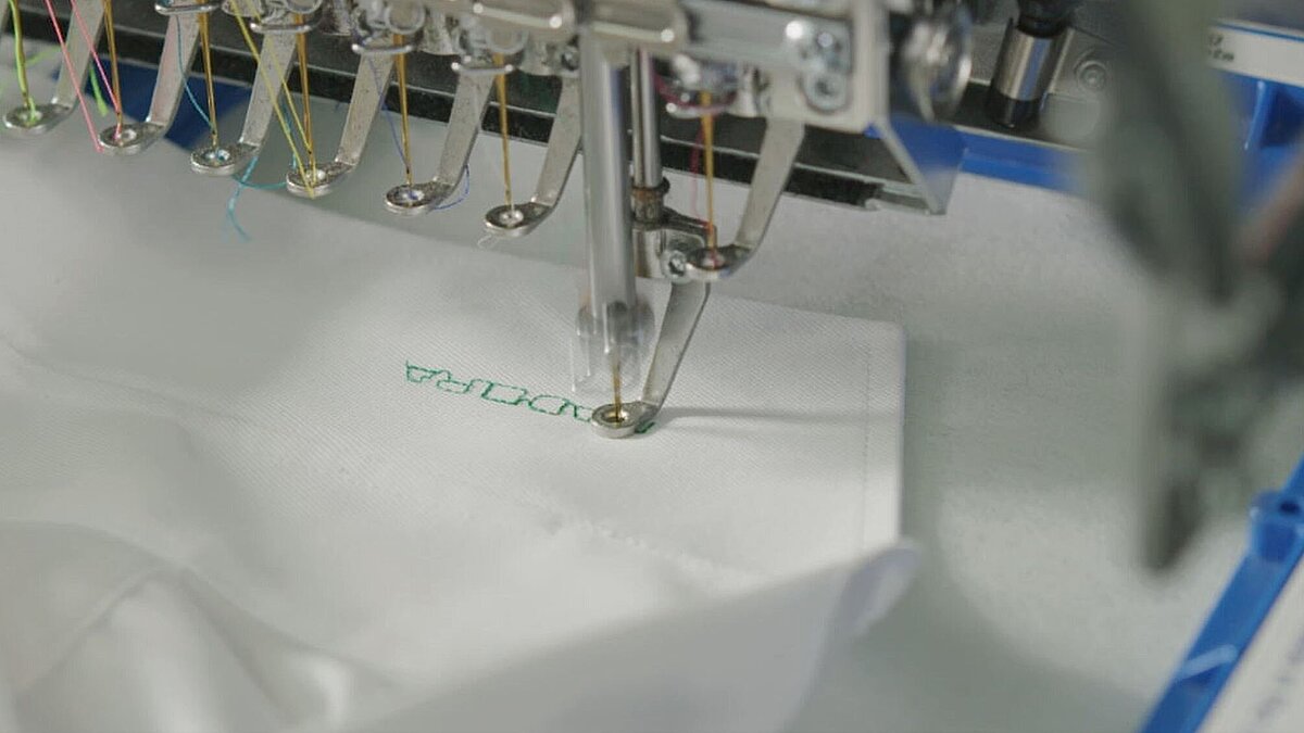 White shirt collar being embroidered using Stick-On adhesive backing