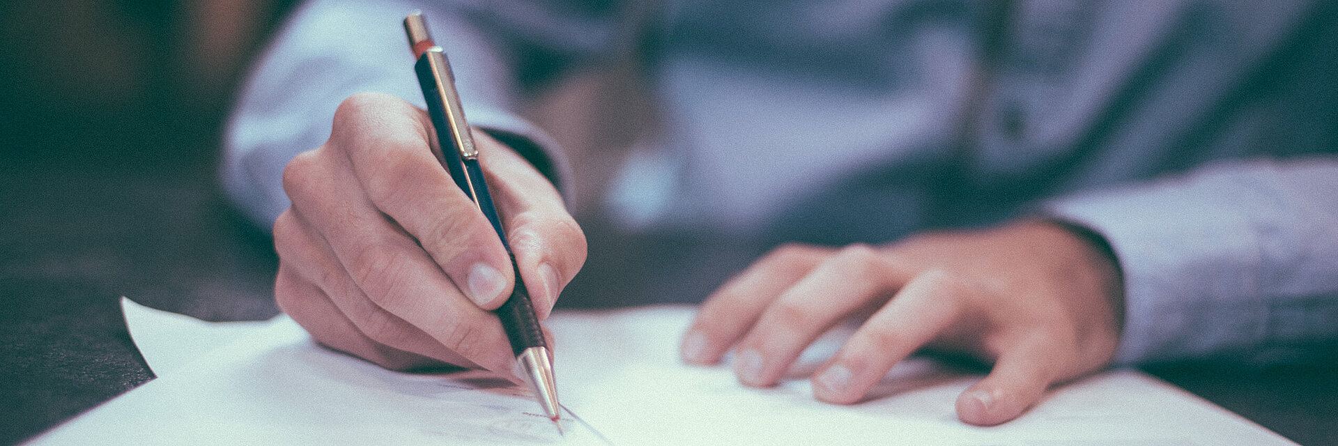 [Translate to Global Portugiesisch:] Businessman writing on a paper