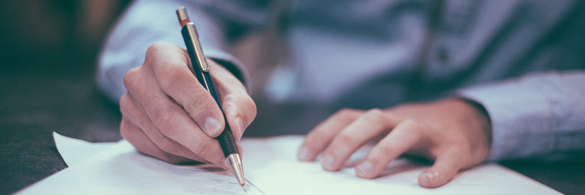 [Translate to Global Spanisch:] Businessman writing on a paper