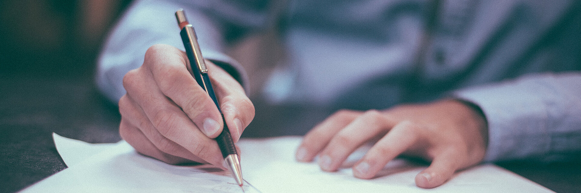 [Translate to Türkisch:] Businessman writing on a paper