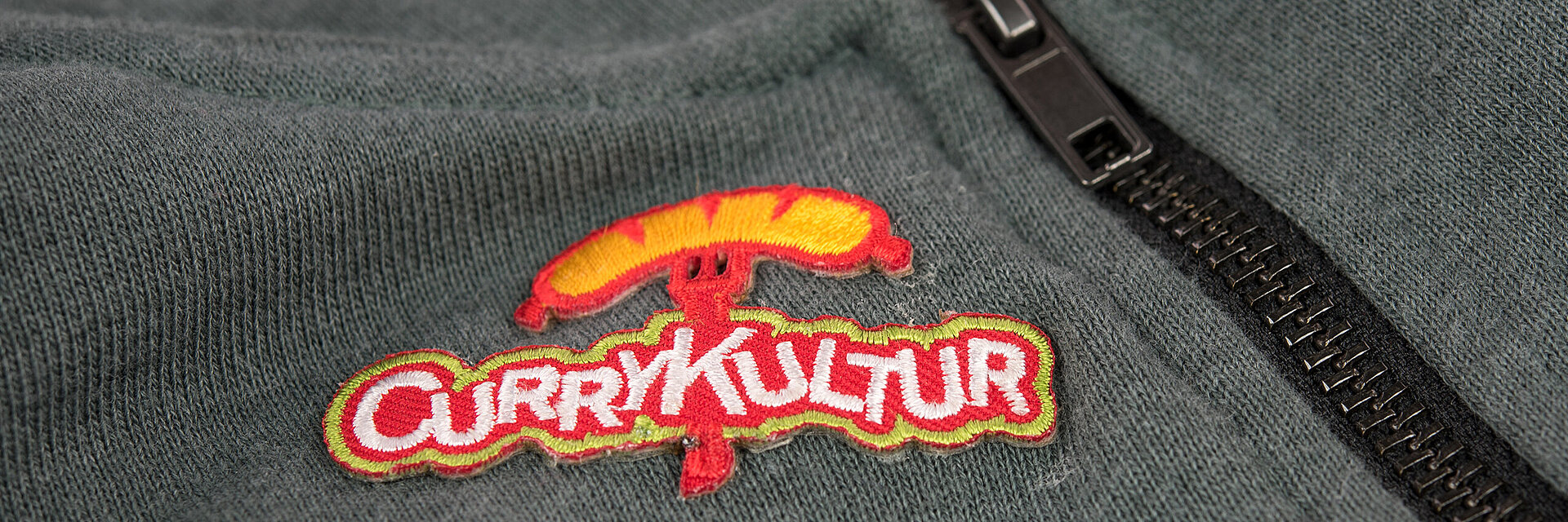 [Translate to Global Deutsch:] embroidered fast food logo "Currykultur"