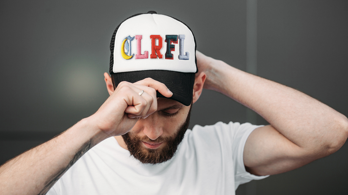 young man wearing a cap with 3D embroidery letters