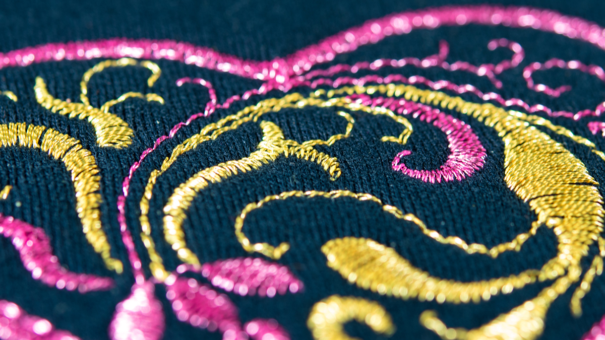 Close-up of an embroidery with pink and yellow thread